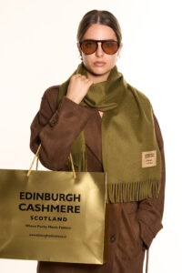 A folded soft beige cashmere scarf in a luxury gift box.