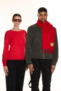 A folded red tartan cashmere scarf in a luxury signature gift box.