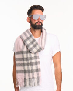 A male model wearing a beige cashmere scarf outdoors.