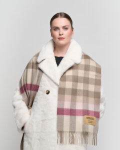 Artisan hands weaving Scottish cashmere on a traditional loom, showcasing premium material.